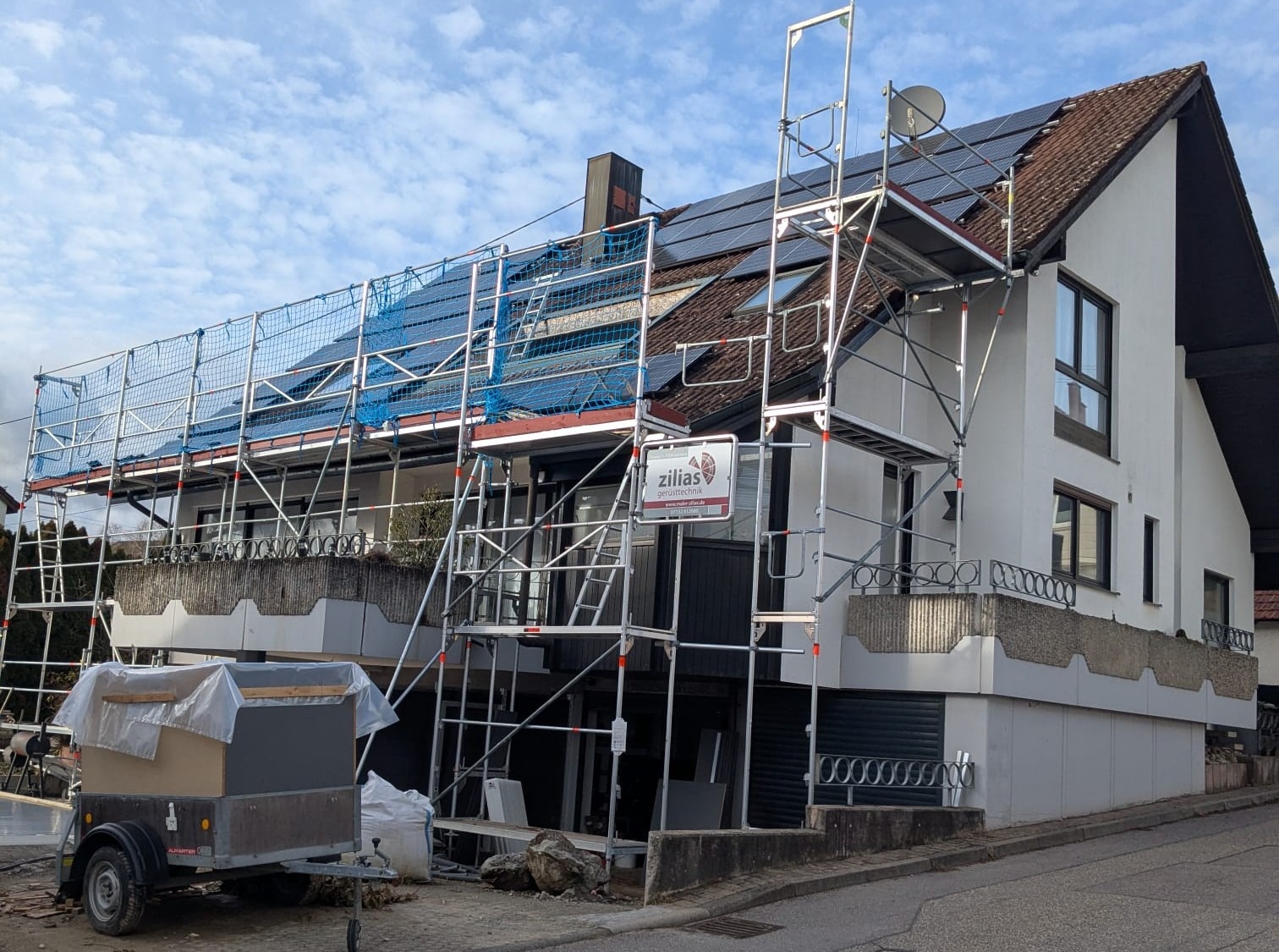 Wohnhaus mit Gerüst und Solarpanel auf dem Dach